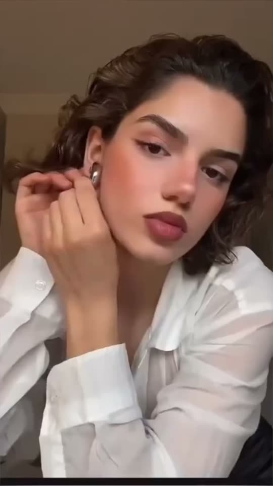 Woman puts on earrings