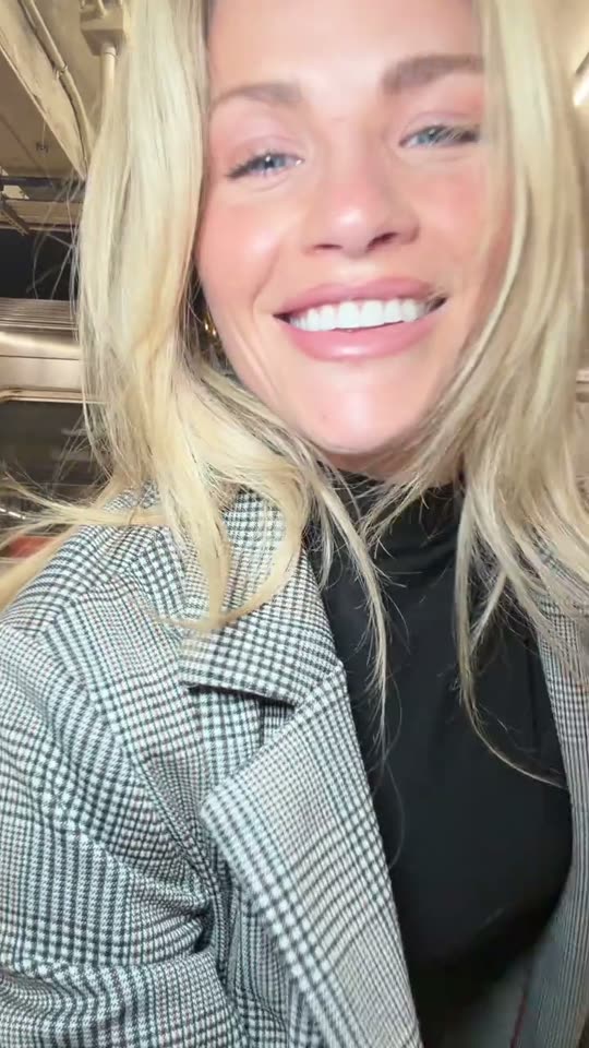Woman smiles in plaid jacket