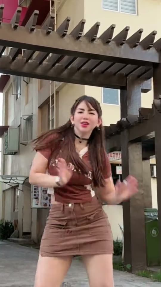 Woman dancing outside in brown