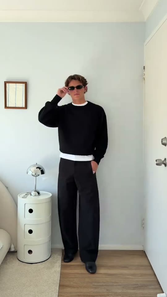 Man poses in black outfit