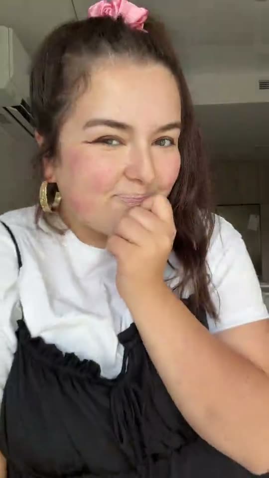 Woman smiles and bites finger