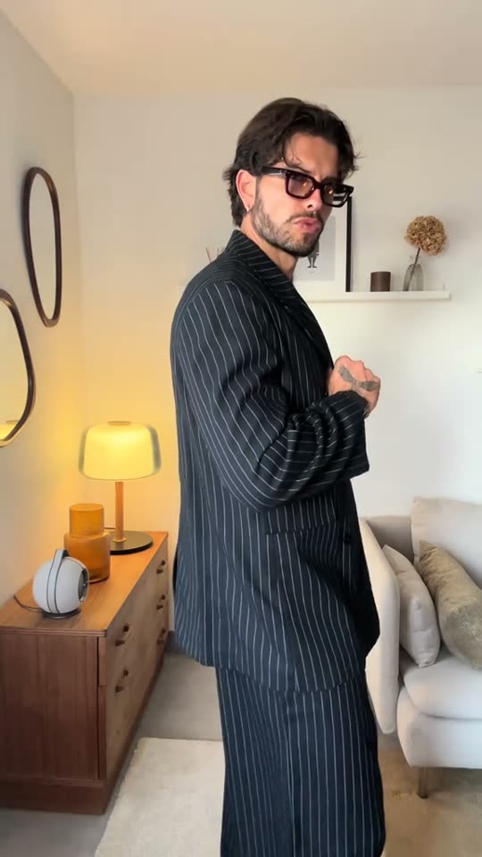 Man poses in pinstripe suit