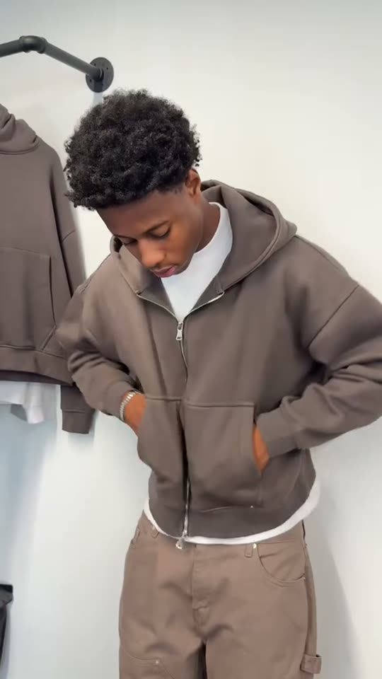 Man trying on a brown hoodie