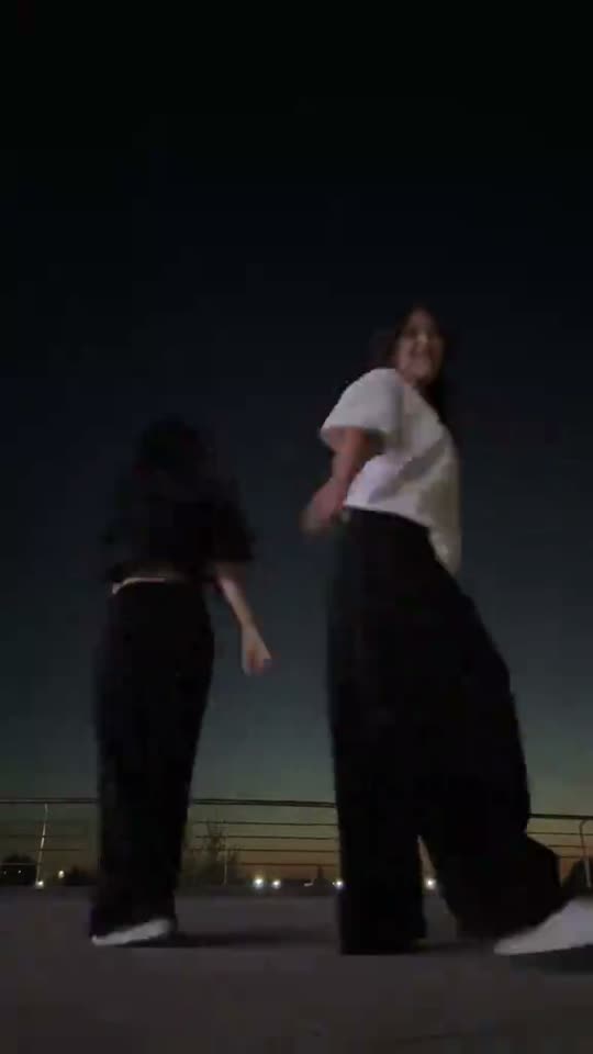Two friends dancing at night