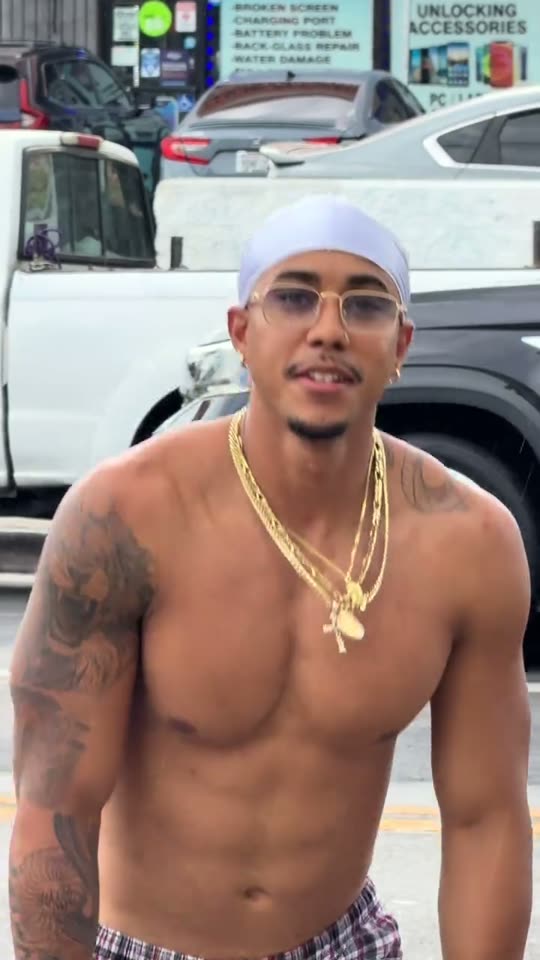Man poses shirtless on street