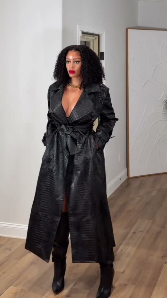 Woman poses in black trench coat