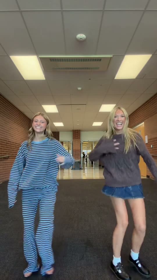 Two girls dancing in a hallway