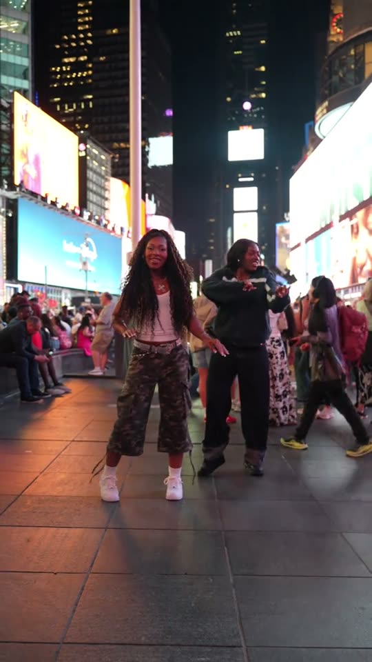 Two women dancing in city