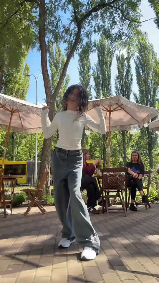 Woman dances in outdoor cafe