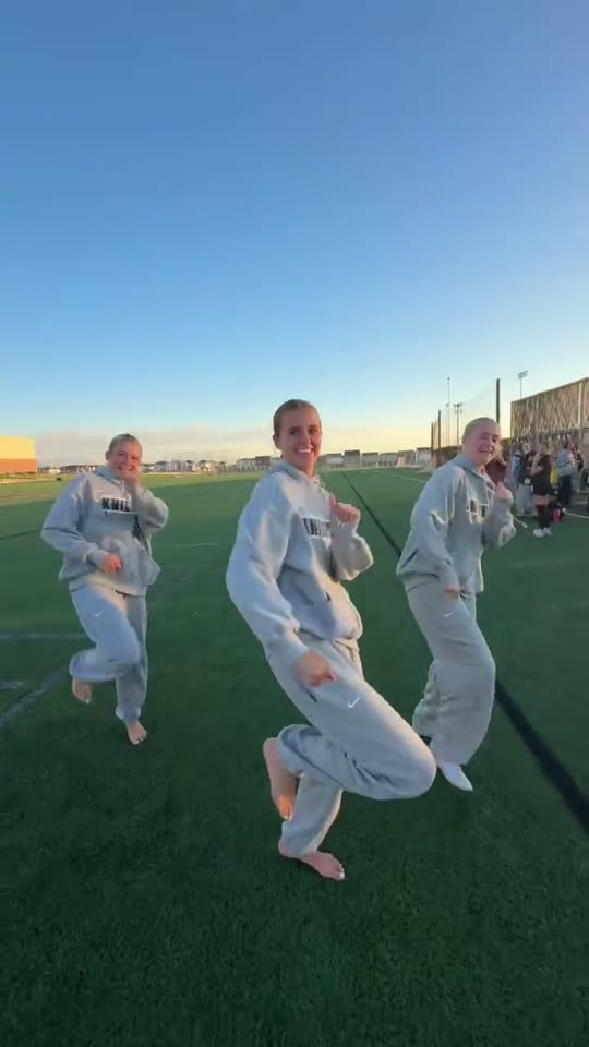 Three women dancing on field