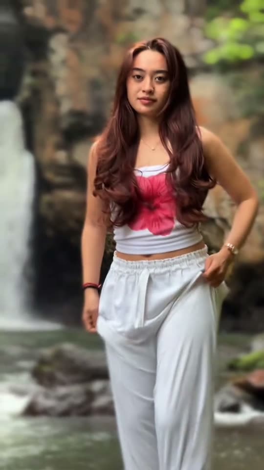 Woman posing by waterfall