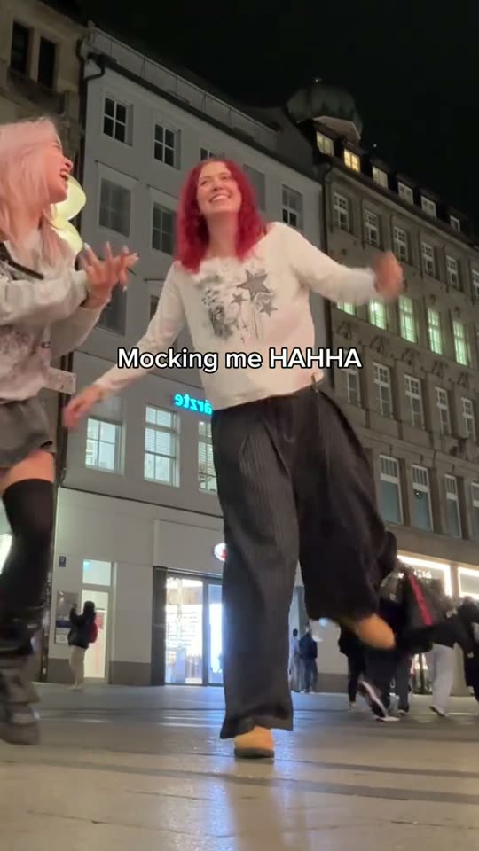Two women dancing on street