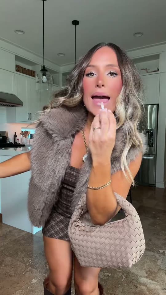 Woman applies lip gloss